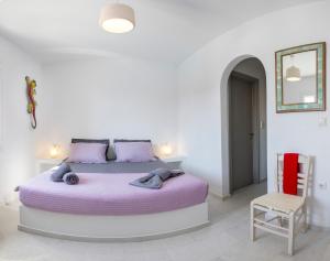 a bedroom with a bed with purple sheets and a chair at Villa Ione in Mikri Vigla +44 photos