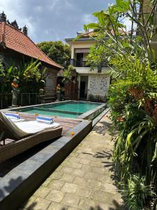 a swimming pool in front of a house at Ariartha homestay in Ubud
