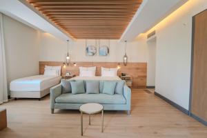 a hotel room with a bed and a blue couch at Miramare Beach Hotel - Ultra All Inclusive in Side