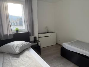 a bedroom with two beds and a window at Sauerland Wellness Apartment mit Sauna und Jacuzzi in Olpe