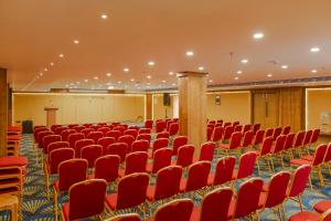 a large room with red chairs and a stage in it at Hotel Sky International in Kizhake Chālakudi