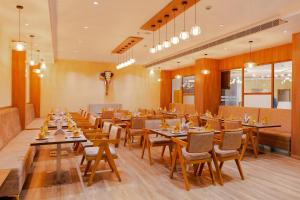 a large dining room with tables and chairs at Hotel Sky International in Kizhake Chālakudi
