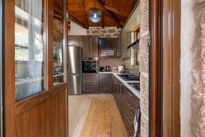 a kitchen with wooden cabinets and stainless steel appliances at Elevi Aria in Tyros