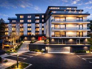 an apartment building at night with a parking lot at Ilma Apartmani Musique in Tuzla