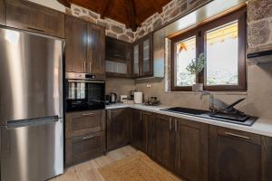 a kitchen with wooden cabinets and a stainless steel refrigerator at Elevi Aria in Tyros +17 photos