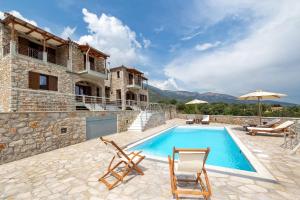 an external view of a villa with a swimming pool at Elevi Aria in Tyros