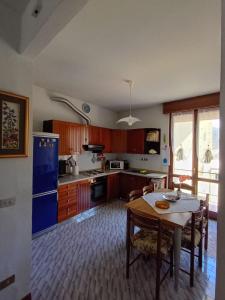 a kitchen with a table and a blue refrigerator at Casa Noemi in IDRO