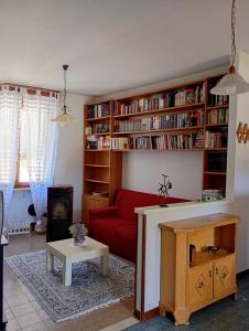 a living room with a red couch and book shelves at Casa Noemi in IDRO