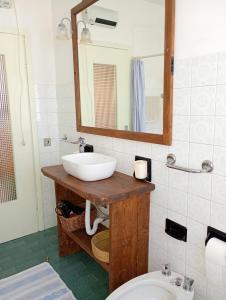 a bathroom with a sink and a mirror and a toilet at Casa Noemi in IDRO +13 photos