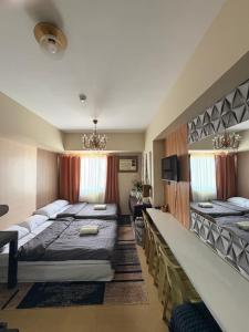 a hotel room with two beds and a desk at Avida Aspira Tower 1 - Chads Unit 8th Floor in Cagayan de Oro +28 photos