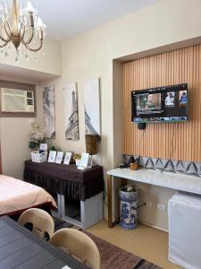 a room with a table and a television on a wall at Avida Aspira Tower 1 - Chads Unit 8th Floor in Cagayan de Oro
