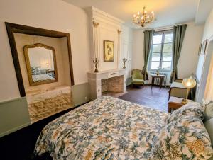 a bedroom with a bed and a fireplace and a mirror at Domaine de la Dordrona in Brantome en Perigord