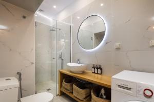 a white bathroom with a sink and a mirror at Old Town Stone Residence in Rethymno +17 photos