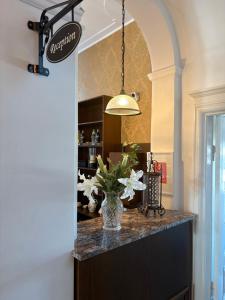 a kitchen with a counter with a vase of flowers at Laholms Stadshotell in Laholm