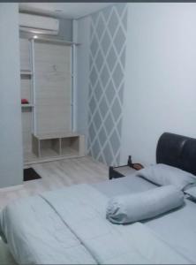 a bedroom with a white bed and a closet at Hotel Permata Inn Ball Room Seroja in Kualakapuas