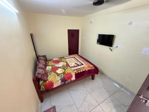 a small bed in a room with a television at Gravity Groups VVJ - Near Jipmer Sangamithra in Pondicherry