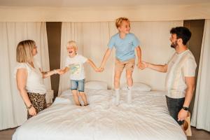 a group of three people jumping on a bed at Greenfields Glamping Durbuy in Durbuy