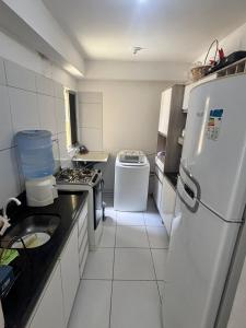 a small kitchen with a refrigerator and a sink at Condomínio Aurora in Paulista