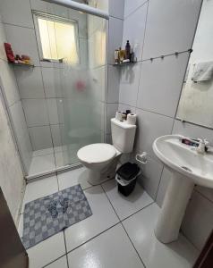 a bathroom with a toilet and a shower and a sink at Condomínio Aurora in Paulista