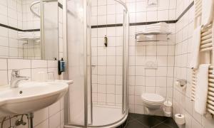 a bathroom with a shower and a sink and a toilet at Hotel Pinzgauerhof by Alpeffect Hotels in Zell am See +33 photos
