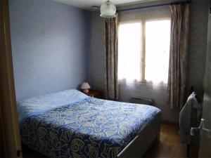 a bedroom with a bed with a blue comforter and a window at Résidence 502-pleneuf Val Andre - Charmante maison de 85m², avec jardin clos dans un quartier calme. MAE-6674 in Pléneuf-Val-André
