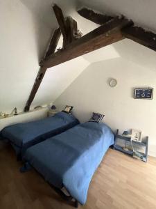 a bedroom with two blue beds in a attic at Résidence 740-pleneuf Val Andre - Belle maison en pierre offrant de beaux volumes à 2km dans la de Pleneuf Val André MAE-8554 in Pléneuf-Val-André