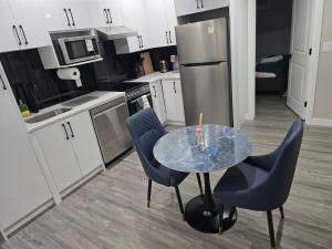 a kitchen with a table and two blue chairs at Cozy 2 Bedroom basement Suite in Calgary