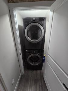 a washer and dryer in a small room at Cozy 2 Bedroom basement Suite in Calgary +3 photos