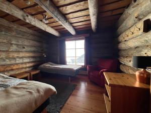 a log cabin bedroom with a bed and a window at Riihilinna Ski Lodge in Muurame