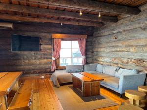 a living room with a couch and a table at Riihilinna Ski Lodge in Muurame