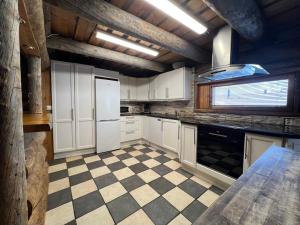 a kitchen with white cabinets and a checkered floor at Riihilinna Ski Lodge in Muurame