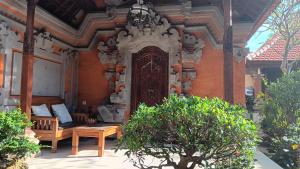 a room with a bed and a bench in a building at Ariartha homestay in Ubud