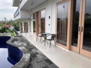 a patio with a table and chairs on a house at Bahtera Canggu in Dalung
