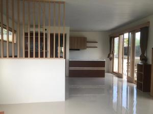 a large kitchen with white walls and wooden cabinets at Bahtera Canggu in Dalung