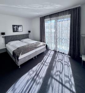 a bedroom with a bed and a large window at Boutique Hotel OASE, mit oder ohne Frühstück buchbar, Parkplatz kostenlos in Bad Ischl