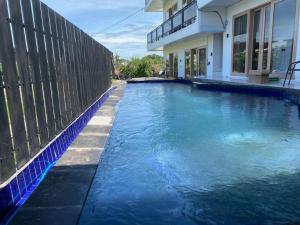 a swimming pool in front of a house at Bahtera Canggu in Dalung