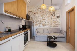 a kitchen with a couch and a table in a room at Old Town Stone Residence in Rethymno