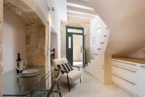 a dining room with a glass table and a staircase at Old Town Stone Residence in Rethymno