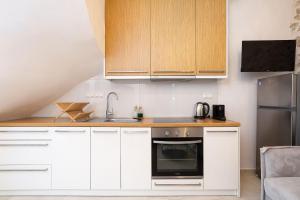 a kitchen with white cabinets and a sink at Old Town Stone Residence in Rethymno