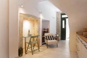 a kitchen with a glass table and a chair at Old Town Stone Residence in Rethymno
