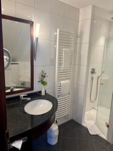 a bathroom with a sink and a shower at Akzent Hotel Höltje in Verden +48 photos