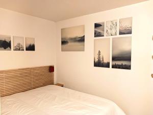 a bedroom with four pictures on the wall at Résidence Cachette - Superbe 2 pièces cabine 4 personnes à Arc 1600, proche des pistes et proche des commerces MAE-7831 in Arc 1600