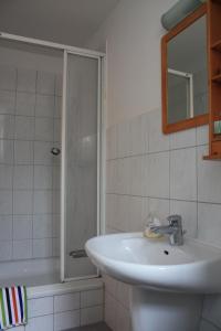 a bathroom with a sink and a shower at Haus Buchheim - Pension am Schloss in Bautzen +25 photos