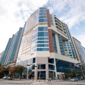 a tall building with many windows on a city street at 센텀스위트호텔 in Busan