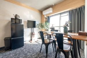 a room with a table and chairs and a refrigerator at b&新大阪店 in Osaka