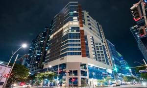 a tall building in a city at night at 센텀스위트호텔 in Busan