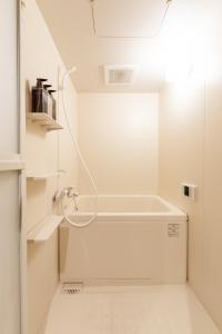 a white bathroom with a bath tub in a room at b&新大阪店 in Osaka +24 photos
