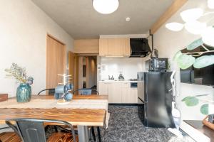 a kitchen with a table and a black refrigerator at b&新大阪店 in Osaka