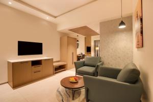a living room with two chairs and a television at Keys Select By Lemon Tree Hotels, Vadodara in Vadodara