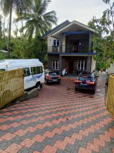 a van and cars parked in front of a house at HALASE HOMESTAY mudigere in Mudigere